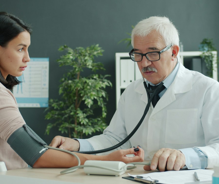 A cardiologist checking an older patient's blood pressure